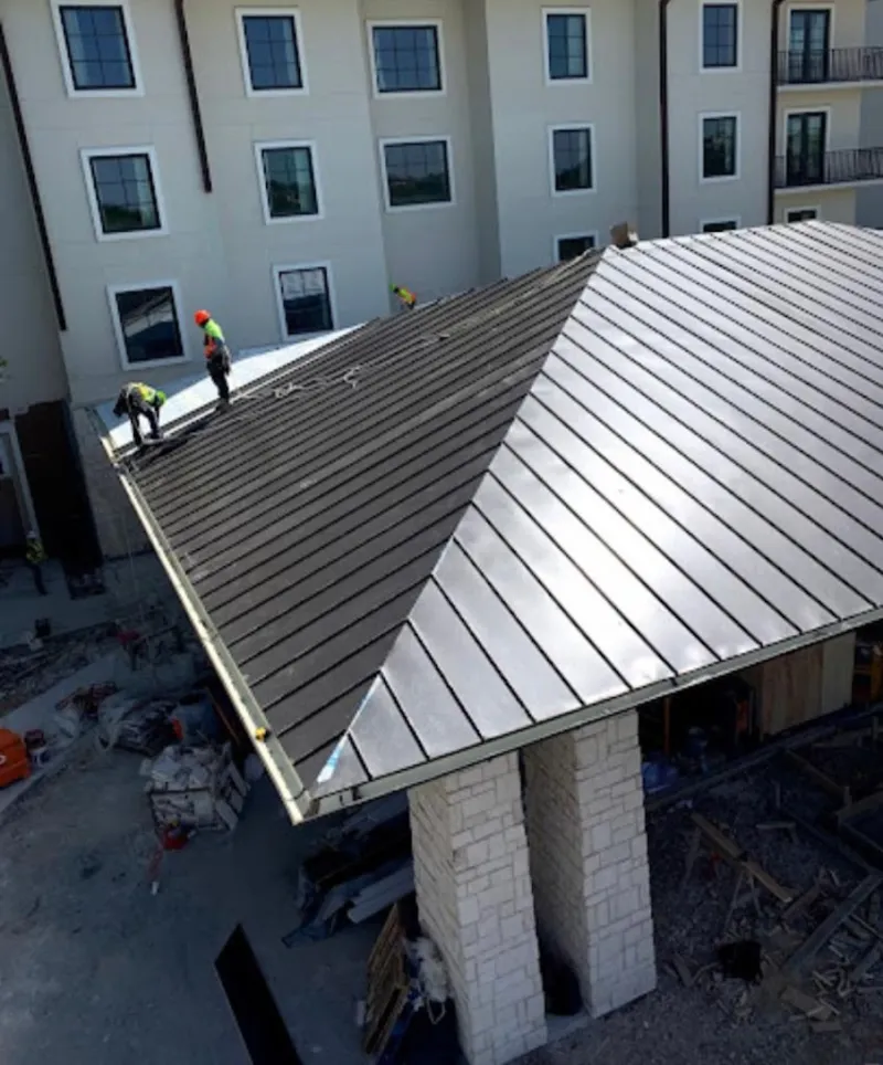Crew installing standing seam metal roof panels on a commercial project in Lake Wylie